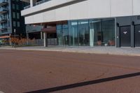 a large white building with many windows near the street side of it on a sunny day