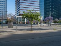 an empty street in front of a building and trees on the other side of the road