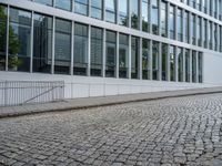 an image of two people riding a bike on the street next to each other and buildings