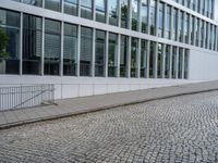 an image of two people riding a bike on the street next to each other and buildings