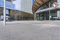 a large building with many windows and a parking area in front of it for walking