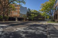 a empty street is surrounded by tall building on a sunny day with no people walking or driving down the sidewalk