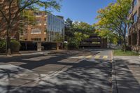 a empty street is surrounded by tall building on a sunny day with no people walking or driving down the sidewalk