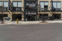 a building with a sign and a bike leaning against the side of it on a street