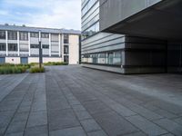 a paved walkway near buildings with an office building in the background, and a lamp post