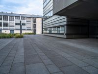 a paved walkway near buildings with an office building in the background, and a lamp post