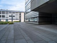 a paved walkway near buildings with an office building in the background, and a lamp post