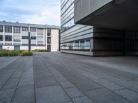 a paved walkway near buildings with an office building in the background, and a lamp post