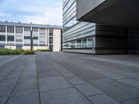 a paved walkway near buildings with an office building in the background, and a lamp post