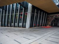 this is an image of a very long building that has many glass windows and a red rug on the outside