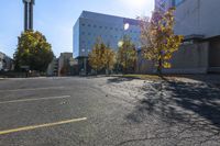 a view of a parking lot with lots of trees and buildings along it in the distance