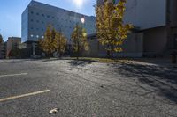 a view of a parking lot with lots of trees and buildings along it in the distance