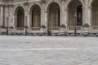 a man is walking on the street with a backpack and some poles and a bench