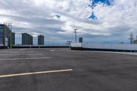 an empty parking lot with white walls and a blue sky behind it, while there is no one on the rooftop, outside