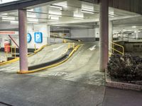 an empty parking garage with a ramp going through the middle of it and cars parked on either side of the stairs