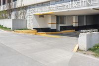 an empty parking garage with a yellow curb and some signs above the door and side of a building