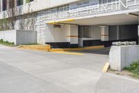 an empty parking garage with a yellow curb and some signs above the door and side of a building