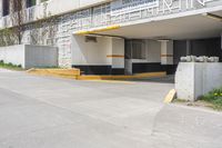 an empty parking garage with a yellow curb and some signs above the door and side of a building