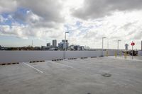 an empty parking lot with white walls and sky in the background's perspective as buildings stand on the far side