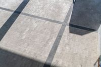 the shadow of an umbrella is on a tiled floor with a window and light coming in from a small window