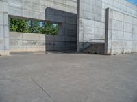 the empty parking lot in front of a wall with apartment buildings on it and a skateboarder on a ramp