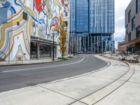 a paved intersection in front of a modern building and some benches are near it,