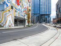 a paved intersection in front of a modern building and some benches are near it,