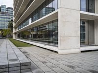 a building with two concrete blocks on a sidewalk in front of it with grass on both sides