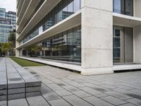 a building with two concrete blocks on a sidewalk in front of it with grass on both sides