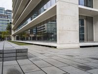 a building with two concrete blocks on a sidewalk in front of it with grass on both sides