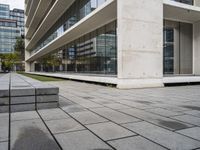 a building with two concrete blocks on a sidewalk in front of it with grass on both sides