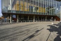 a modern building with lots of glass on the outside and inside of it, with a pedestrian pathway outside