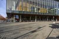 a modern building with lots of glass on the outside and inside of it, with a pedestrian pathway outside