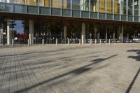 a modern building with lots of glass on the outside and inside of it, with a pedestrian pathway outside