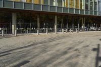 a modern building with lots of glass on the outside and inside of it, with a pedestrian pathway outside