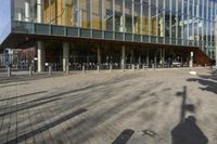 a modern building with lots of glass on the outside and inside of it, with a pedestrian pathway outside