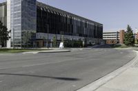 the large building on the corner of an empty lot with trees and shrubs around it