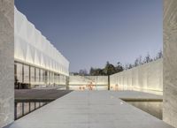 the walkway leads to a reflecting pool in the center of the courtyard, as well as an empty building