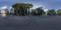 a view from a parking space looking across a street into buildings with trees and plants