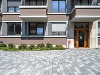 a driveway leading to a modern building with a few windows and balcony railings on the side of it