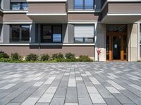 a driveway leading to a modern building with a few windows and balcony railings on the side of it