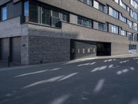 a parking garage under a building that says pier on it and a building with a bike on the sidewalk