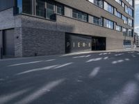 a parking garage under a building that says pier on it and a building with a bike on the sidewalk