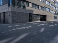 a parking garage under a building that says pier on it and a building with a bike on the sidewalk