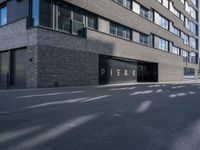 a parking garage under a building that says pier on it and a building with a bike on the sidewalk