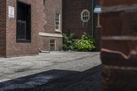 a white fire hydrant in between two buildings and a walkway with cement next to it