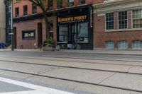 a bicycle parked on a trolley track in front of a burger's finest store