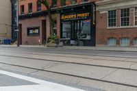 a bicycle parked on a trolley track in front of a burger's finest store