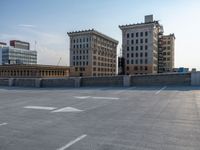 several large empty parking spaces in the city with buildings nearby in front of them -