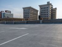 several large empty parking spaces in the city with buildings nearby in front of them -